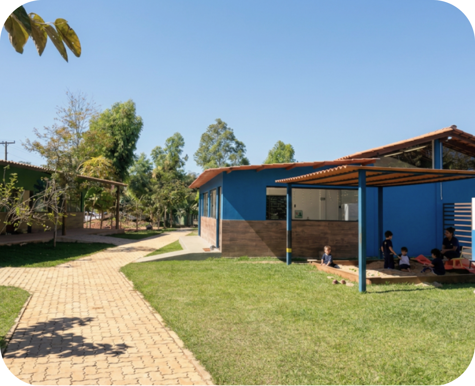 Área externa da Escola Fonte Real com caminho de tijolos e crianças